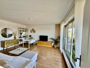 un salon avec un canapé, une table et une télévision dans l'établissement Appartement vue sur Tour Eiffel, à Garches 7 autres photos