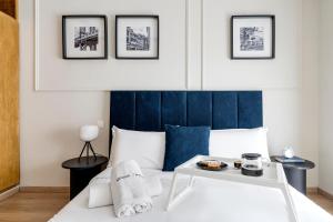 The Loft Residence by GoodMove - Maarif Casablanca في الدار البيضاء: غرفة نوم مع سرير أبيض مع اللوح الأمامي الأزرق