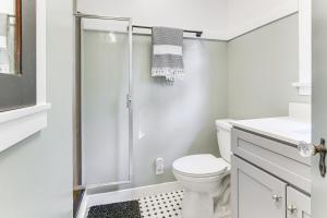 a white bathroom with a toilet and a shower at Steps to Lake Arrowhead Village Chic Apartment in Lake Arrowhead