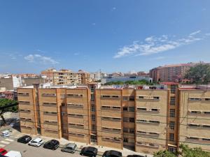 un grande edificio con auto parcheggiate in un parcheggio di Renovated & Comfortable Apartment with Lift a Castellón de la Plana