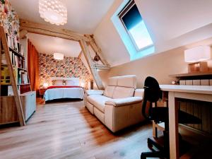 ein Wohnzimmer mit Sofa und Bett in der Unterkunft Chez Maméta - Séjour à Auxerre in Auxerre