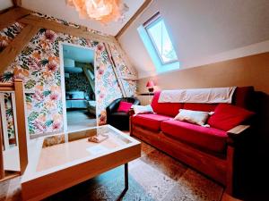 ein Wohnzimmer mit einem roten Sofa und einem Fenster in der Unterkunft Chez Maméta - Séjour à Auxerre in Auxerre