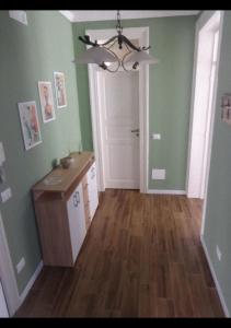 una cucina con pareti verdi e un lampadario di Thalìa a Trapani