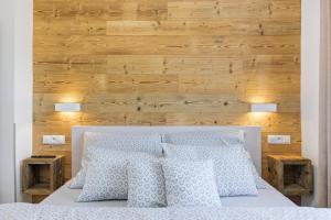 una camera da letto con un letto bianco con una parete di legno di Apartmán Géčko a Boží Dar