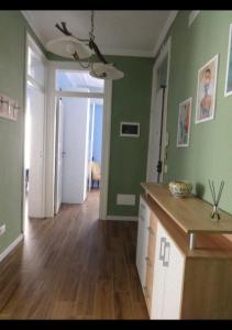 una cucina con pareti verdi e pavimenti in legno di Thalìa a Trapani