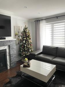 a living room with a christmas tree and a couch at Modern Retreat with Hot tub by YYZ, 20min to CN Tower in Toronto