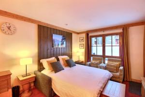 une chambre avec un grand lit dans une pièce dans l'établissement ARC 1950 - Appartement 6 personnes - Départ ski aux pieds - Sauna, Hammam, Jacuzzi, Piscine chauffée, à Arc 1950 26 autres photos