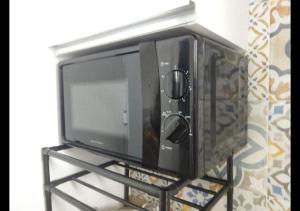 un forno a microonde appoggiato su un supporto a parete di Thalìa a Trapani