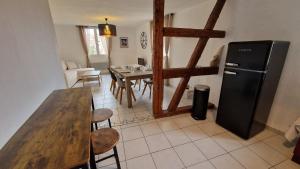 a kitchen and dining room with a table and a refrigerator at La vita è bella in Sélestat