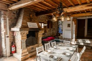 Vacation Home Tuscany Pisa-Lucca 0 في Filettole: غرفة طعام مع طاولة ومدفأة حجرية