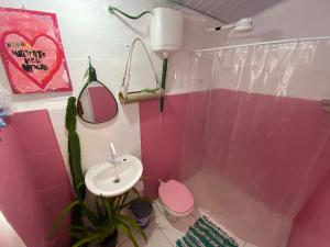 a pink bathroom with a toilet and a sink at Tia Chica Camburi in Camburi +33 photos