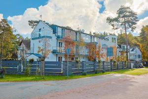 una gran casa blanca detrás de una valla en Illusione, en Pobierowo