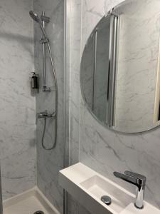 a bathroom with a shower and a sink and a mirror at Hôtel Montmartre - Nouvellement Rénové in Paris +39 photos