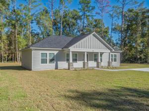 una piccola casa bianca con un cortile di Seabreeze Pines a Crawfordville