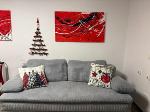 Sala de estar con sofá gris y árbol de Navidad en Boutique Apartments, en Liubliana