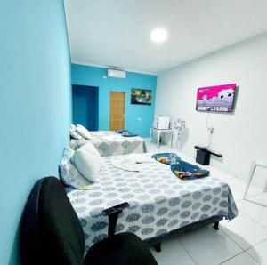 una stanza con due letti e una parete blu di pousada paraíso a Canudos