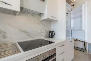 Una cocina blanca con gabinetes blancos y un fregadero. en Harmony's Nest - Vicino a treno e Fiera Milano, en Rho