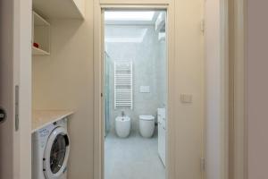 Un baño con lavadora y lavadora y secadora. en Harmony's Nest - Vicino a treno e Fiera Milano, en Rho