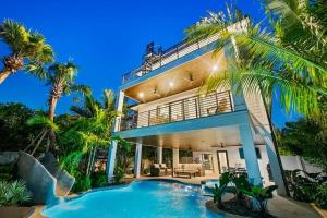 een huis met een zwembad en palmbomen bij Summer Shores Estate in Bailey Hall