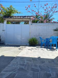 Ar condicionado ! Pousada familiar natureza Rustic في إلها كومبريدا: كرسيان زرقان يجلسون بجوار سياج