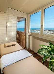 two beds in a room with a view of the beach at Park Hotel Cattolica & Restaurant in Cattolica
