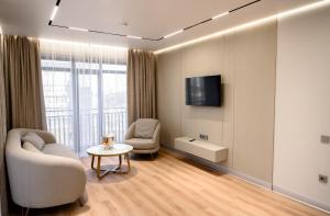 a living room with a couch and a tv and a table at Rakhat Hotel in Oral
