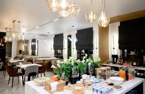 a dining room with tables and chairs and chandeliers at Rakhat Hotel in Oral