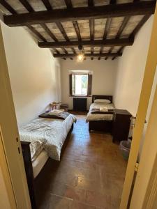 a room with two beds and a window at Il Cantico in Cagli