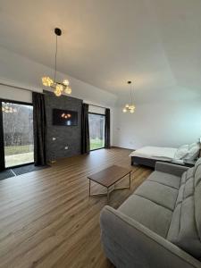 a living room with a couch and a table at Mountain House Transalpina in Novaci +18 photos