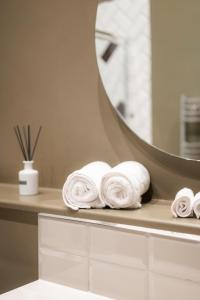 a pile of towels on a counter with a mirror at The Dome House in Bowness-on-Windermere +38 photos