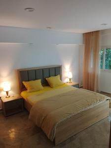 ein Schlafzimmer mit einem großen Bett mit zwei Lampen in der Unterkunft Dar Sabrina Bizerte Corniche in Banzart