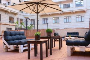 a patio with tables and chairs and an umbrella at lullaby by hamilton in Barcelona