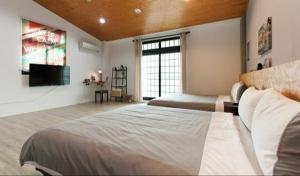 een slaapkamer met een groot bed en een televisie bij 約旦河民宿包棟附電動麻將 in Hsia-ch'ing