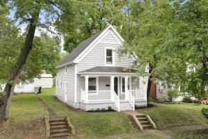 a white house with a porch and stairs in a yard at Sweet Retreat 3 Mins to Notre Dame Eddy St Commons and Memorial Hospital in South Bend