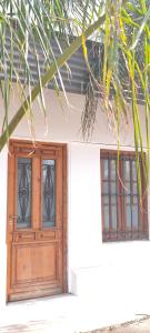 a house with a wooden door and two windows at Casa Rio in Cruz del Eje