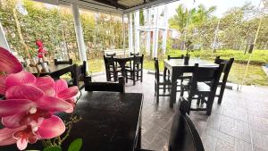 a dining room with tables and chairs and a flower at Hotel Sleep Well in Filandia +10 photos