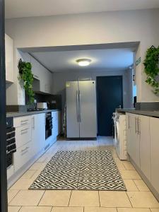 uma cozinha com armários brancos e uma geladeira em Allon Manor De'Grey em Hull