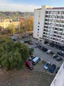Un estacionamiento con autos estacionados frente a un edificio. en DhaliHOUSE, en Mealhada