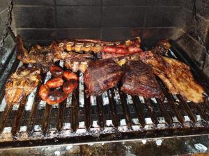 a grill with meat and other food on it at Las Retamas B&B in Ushuaia