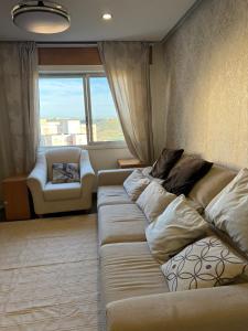 una sala de estar con un sofá largo frente a una ventana en DhaliHOUSE, en Mealhada