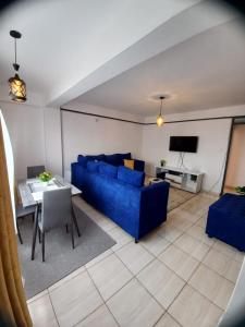 a living room with a blue couch and a table at Delightfulstaycation in Nanyuki