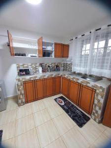 a large kitchen with wooden cabinets and a tile floor at Delightfulstaycation in Nanyuki