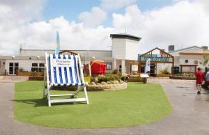 a beach chair sitting on a lawn in front of a store at frankys presthaven retreat in Talacre