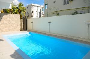 a large blue swimming pool next to a building at Lamarel Beach House 2 in Flic-en-Flac