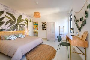 a bedroom with a large bed with a desk and a desk at Lamarel Beach House 2 in Flic-en-Flac +27 photos