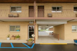 an outside view of a building with a parking lot at Capital O Swan Inn Comstock Park in Comstock Park