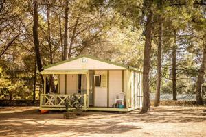 a small house in the woods with a tree at ZEcamping 3 étoiles animaux acceptés in Sartène