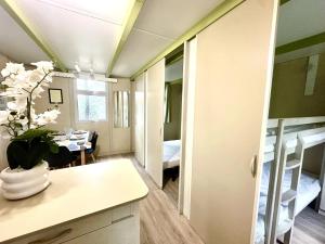 a room with a kitchen and a dining room with bunk beds at ZEcamping 3 étoiles animaux acceptés in Sartène