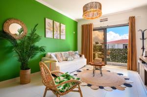 a living room with a green wall at Lamarel Beach House 2 in Flic-en-Flac