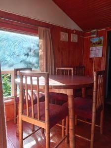 ein Holztisch und Stühle in einem Zimmer in der Unterkunft Casa silvia in Llanquihue
